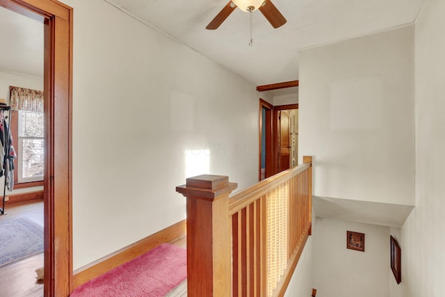 hall featuring wood finished floors and an upstairs landing