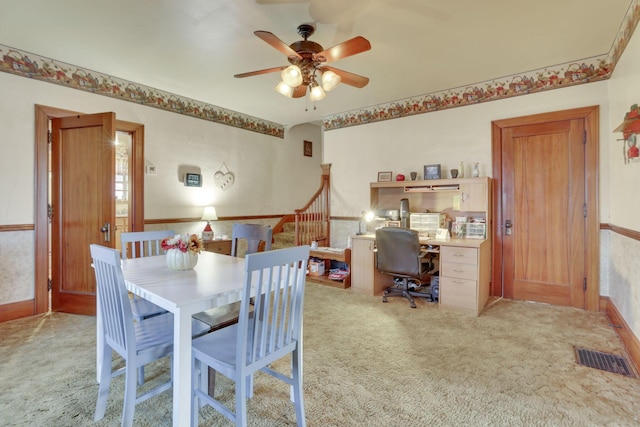 dining room with stairway, wainscoting, visible vents, and light colored carpet