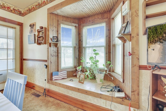 dining room featuring a wainscoted wall, visible vents, and wooden walls