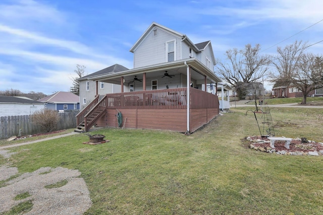 view of front facade featuring stairway, a ceiling fan, fence, a fire pit, and a front lawn