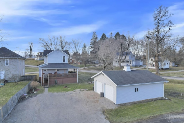 view of front of property with a garage, an outbuilding, a residential view, and a front yard