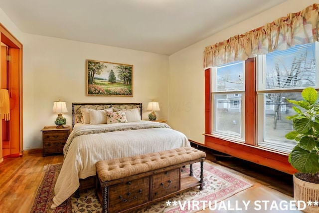 bedroom with light wood-style flooring and baseboards