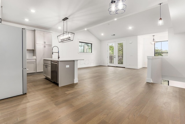 kitchen with a kitchen island with sink, dishwasher, pendant lighting, and white refrigerator