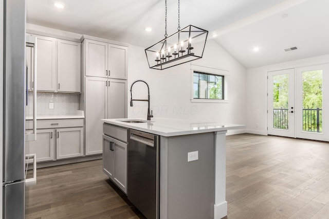 kitchen featuring decorative backsplash, appliances with stainless steel finishes, a kitchen island with sink, sink, and gray cabinets