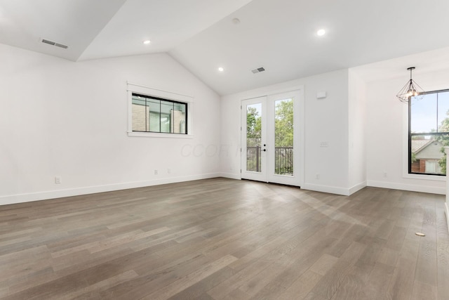 empty room with french doors, lofted ceiling, light hardwood / wood-style flooring, and a notable chandelier