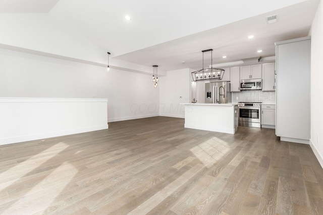 unfurnished living room with light hardwood / wood-style flooring and vaulted ceiling