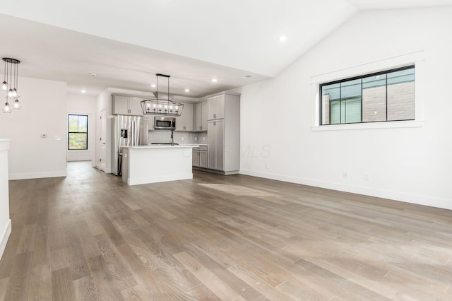 unfurnished living room featuring light wood-type flooring and lofted ceiling