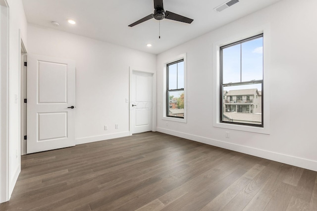 unfurnished room featuring ceiling fan and dark wood-type flooring