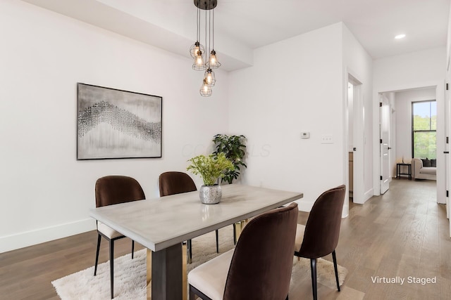 dining room featuring wood-type flooring and an inviting chandelier