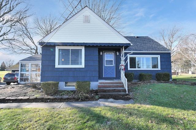 bungalow-style home with a front yard and a sunroom