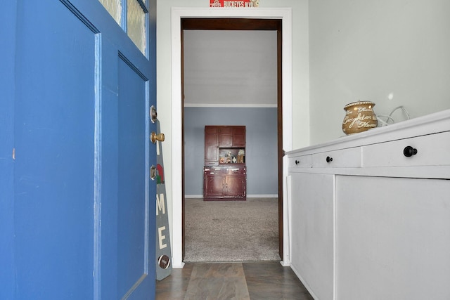 hallway featuring dark colored carpet