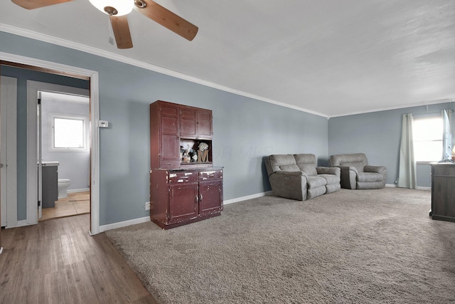 living room featuring crown molding, ceiling fan, and light carpet