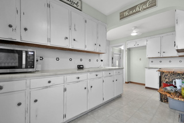 kitchen featuring backsplash, ceiling fan, and white cabinets