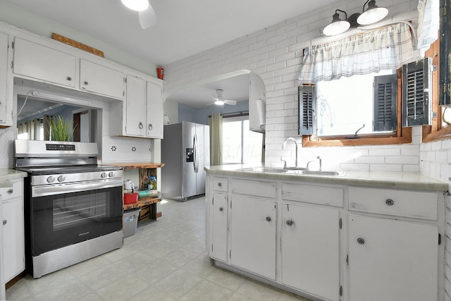 kitchen with white cabinets, appliances with stainless steel finishes, decorative backsplash, and sink