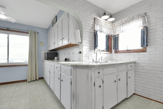 kitchen featuring tile countertops, white cabinetry, sink, and tasteful backsplash