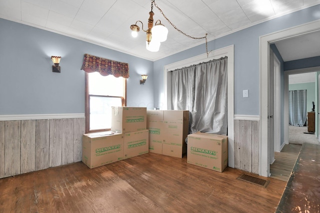 unfurnished bedroom featuring dark wood-type flooring and a notable chandelier