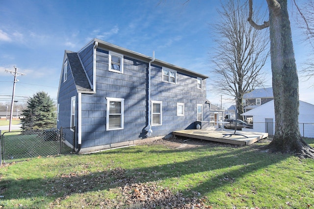 rear view of property with a wooden deck and a yard