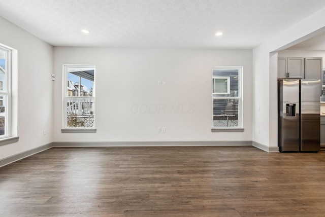 unfurnished room with dark hardwood / wood-style floors and a textured ceiling