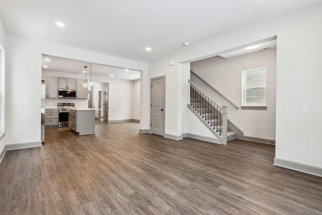 unfurnished living room with dark hardwood / wood-style floors and a textured ceiling