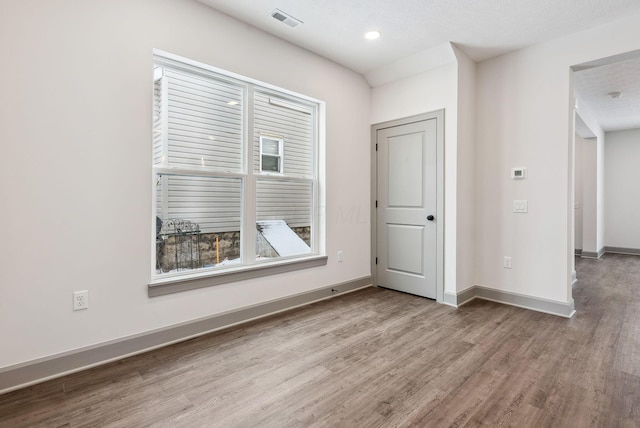 spare room with hardwood / wood-style floors and a textured ceiling