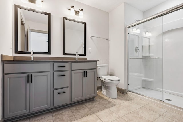 bathroom with vanity, toilet, and a shower with door