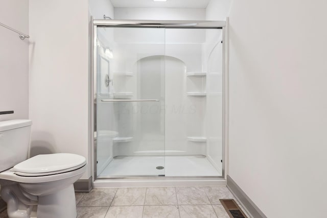 bathroom featuring toilet and a shower with shower door