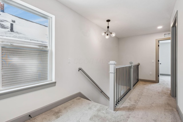 stairs featuring carpet and a notable chandelier