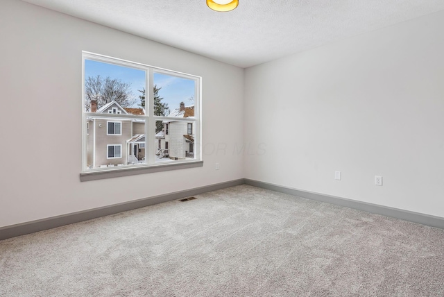 empty room with carpet and a textured ceiling