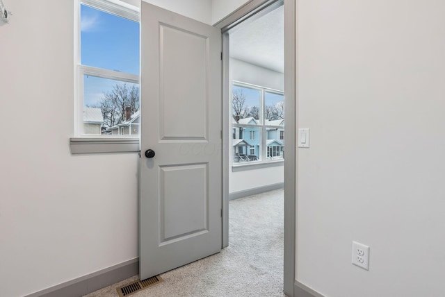 doorway to outside featuring light colored carpet