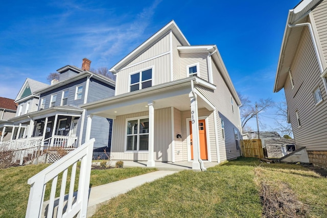 view of front facade with a porch, board and batten siding, and a front lawn