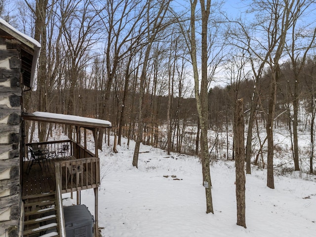 snowy yard featuring a wooden deck