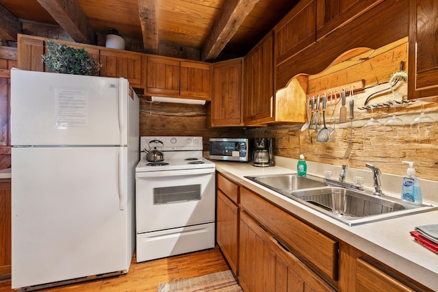 kitchen featuring light hardwood / wood-style floors, sink, beamed ceiling, white appliances, and wooden ceiling