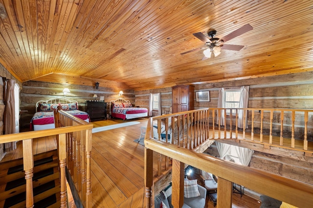 interior space with wooden ceiling, wood walls, log walls, and vaulted ceiling