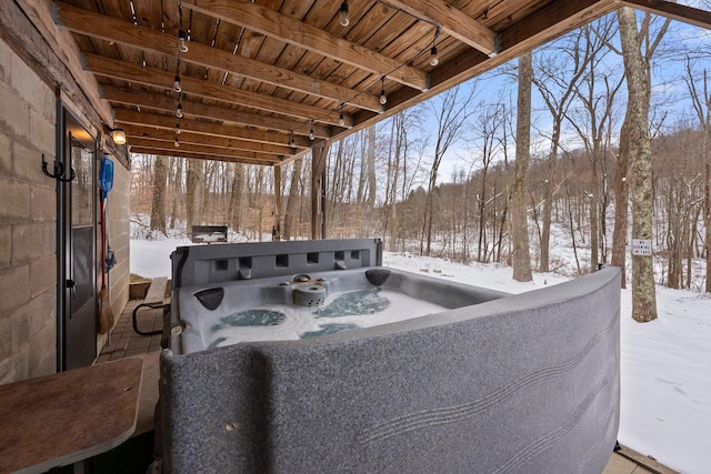 snow covered patio with a hot tub