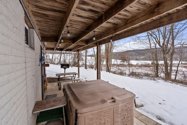 snow covered deck with a hot tub