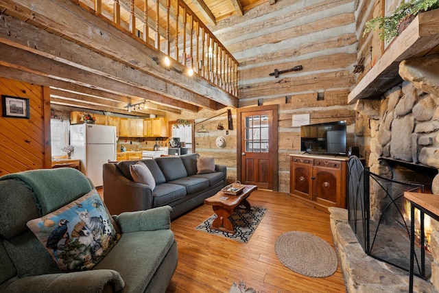 living room with beamed ceiling, wooden walls, light wood-type flooring, wood ceiling, and high vaulted ceiling