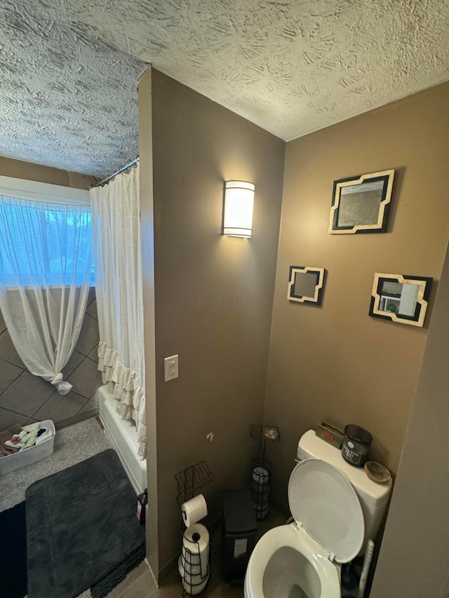 bathroom with a textured ceiling, toilet, and walk in shower