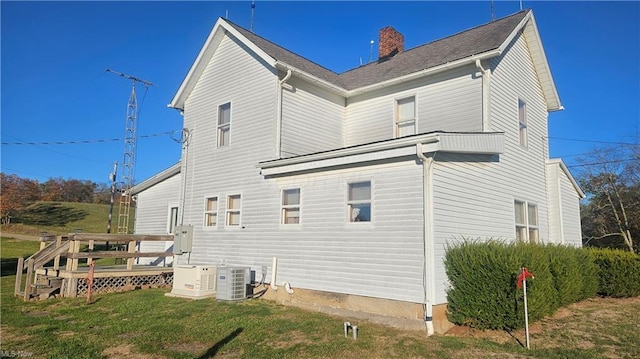 rear view of house with central AC unit, a lawn, and a wooden deck