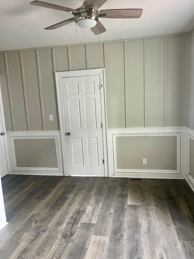 unfurnished bedroom featuring ceiling fan and dark hardwood / wood-style flooring