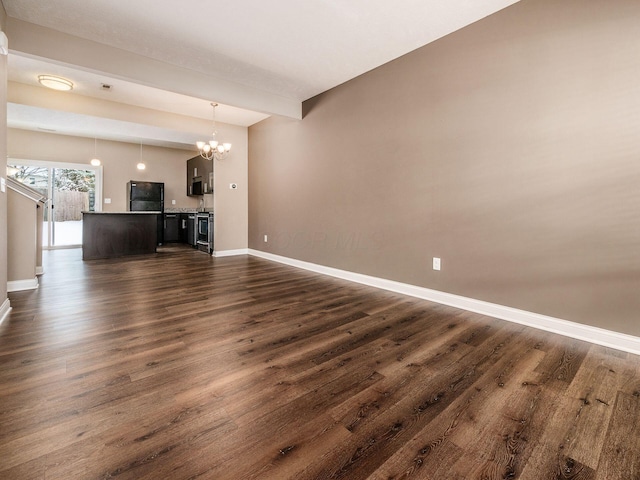 unfurnished living room with a notable chandelier and dark wood-type flooring