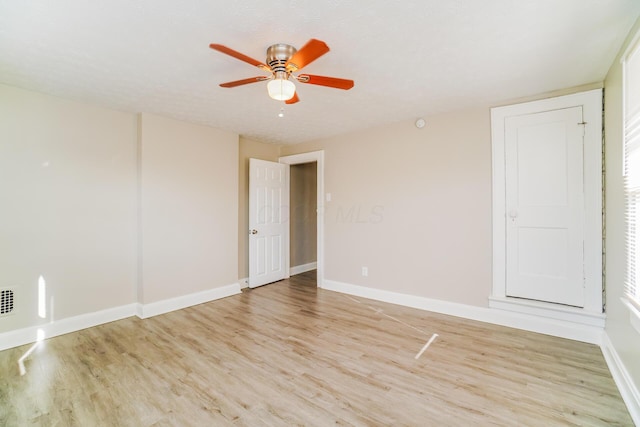 empty room with ceiling fan and light hardwood / wood-style floors