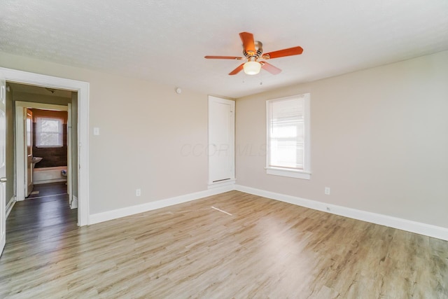 spare room featuring ceiling fan, a textured ceiling, and light wood-type flooring