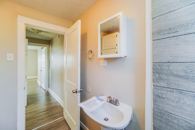 bathroom featuring sink, hardwood / wood-style flooring, and a textured ceiling