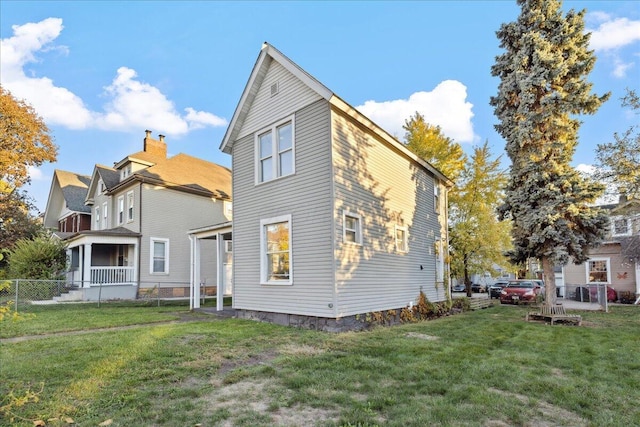 rear view of property featuring a lawn