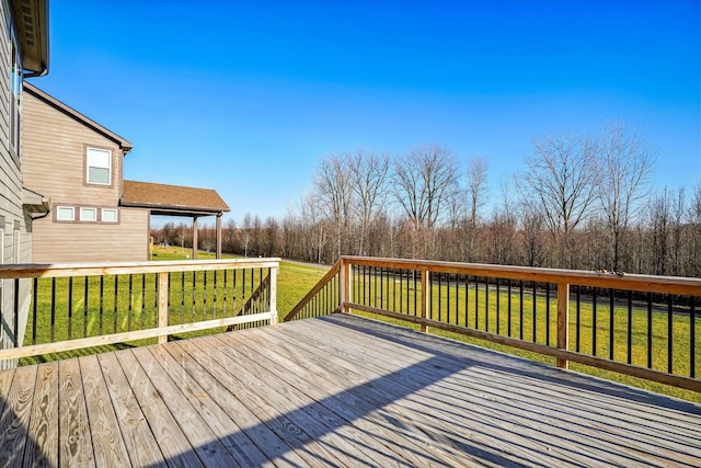 wooden deck featuring a lawn