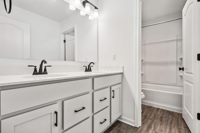 full bathroom with shower / tub combination, vanity, wood-type flooring, and toilet