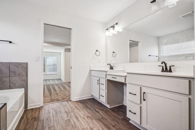 bathroom with a bathtub, hardwood / wood-style floors, and vanity