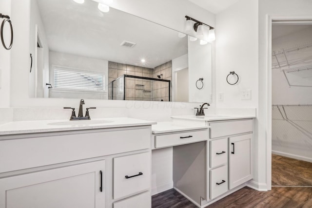 bathroom featuring a shower with door, vanity, and wood-type flooring