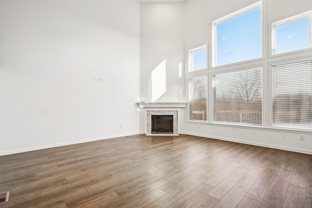 unfurnished living room featuring dark wood-type flooring and a high ceiling