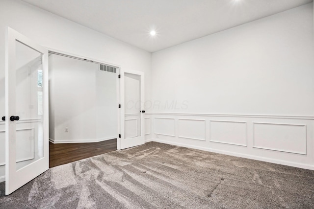 unfurnished room featuring dark colored carpet